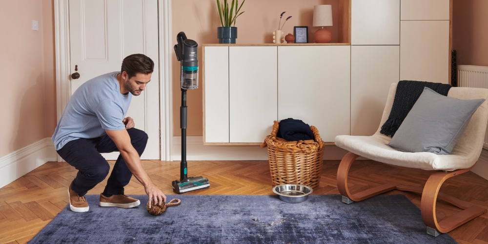 Man cleaning a dark blue rug